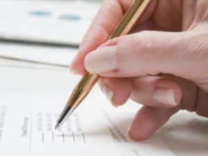 Hand Holding Pen Signing Papers